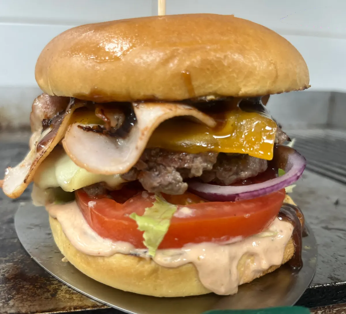 Burger con bacon, cheddar, tomate y cebolla morada